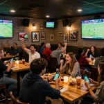 Excited fans watching a match and placing bets with https://nddo.org in a lively sports bar atmosphere