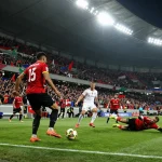 7m football match scene with fans, intense moment capturing players and stadium atmosphere