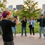 How to get famous on TikTok: vibrant urban scene with young creator filming dance challenge during golden hour.