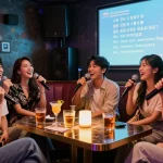 Enjoying 제주유흥 nightlife with friends in a karaoke room filled with drinks and vibrant decor.